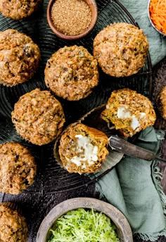 carrot muffins with shredded cheese and other ingredients on a black plate next to a bowl of salad