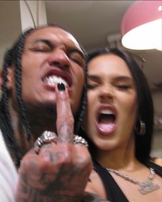 two people with their mouths open and one pointing at the camera while the other holds his finger up