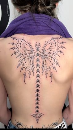 the back of a woman's tattoo with an intricate design on her lower back