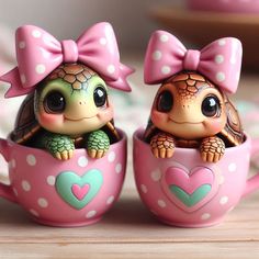 two little turtle figurines sitting inside of pink cups with polka dots on them