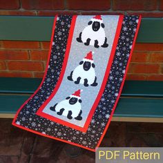 a bench with a quilted blanket hanging from it's side and two sheeps on the back