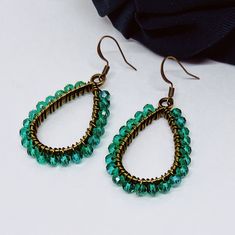 These lovely earrings are handmade using green crystal glass beads. The beads are carefully and individually wrapped around bronze teardrop pendants with bronze, tarnish-resistant wire and hang from hypoallergenic bronze earring hooks. The earrings measure approximately 2" long from the top of the earring hook to the bottom teardrop pendant. (Please see the pictures that include a measuring tape and/or quarter for size reference.)  They are perfect to give as a gift or to treat yourself to something special.  Colors may appear slightly different in images when displayed on your screen. Cotton Filled Box Included. Handmade in the USA. ------  Find more Beautiful Pieces at AshbeesAccessories 🛍 Shop: https://www.etsy.com/shop/AshbeesAccessories Necklaces: https://www.etsy.com/shop/AshbeesAcc Cheap Green Beaded Teardrop Earrings, Green Teardrop Beaded Earrings With Wire Wrap, Green Teardrop Beaded Earrings With Wire Wrapped Detail, Green Wire Wrapped Teardrop Beaded Earrings, Green Teardrop Wire Wrapped Beaded Earrings, Handmade Green Crystal Metal Earrings, Green Teardrop Earrings With Faceted Beads, Teardrop Green Crystal Earrings, Green Teardrop Crystal Earrings Handmade