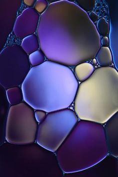 an abstract photo of water and rocks in blue, purple and yellow colors on a black background