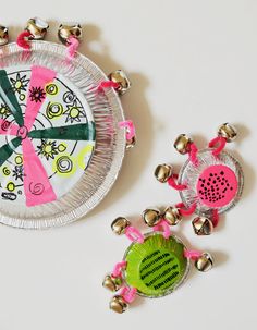 a paper plate with bells attached to it next to a small metal object that looks like a clock