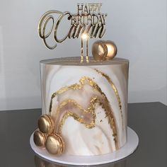 a white and gold birthday cake on a table