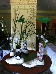 there are two vases with plants and golf balls on the table