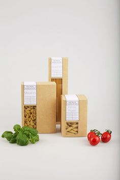 three boxes with pasta and tomatoes next to each other