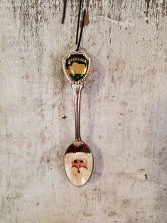 a spoon hanging from a wall with a santa clause face on it's side