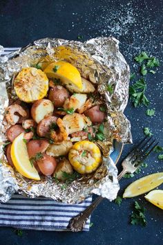 shrimp and potatoes wrapped in foil with lemon wedges on the side for garnish