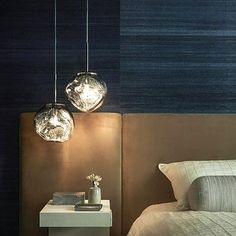 two lights hanging over a bed in a bedroom