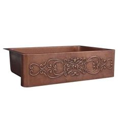 a brown planter with an ornate design on the front and sides, sitting on a white background