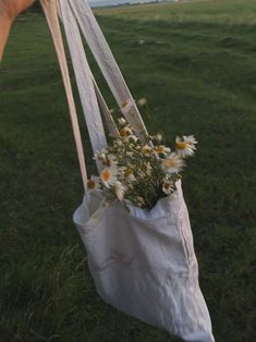 a person holding a bag with flowers in it