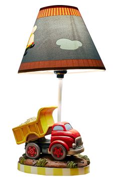 a lamp that has a red truck on it and a yellow dump truck under the shade