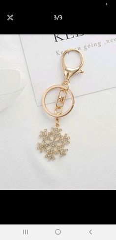 a gold key chain with a snowflake charm