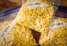 four bags of corn sitting on top of a wooden table