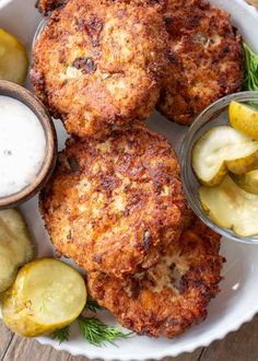 crab cakes with lemon and dill pickles on a white plate