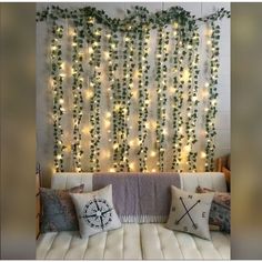 a living room filled with lots of furniture and lights on the wall above it's headboard