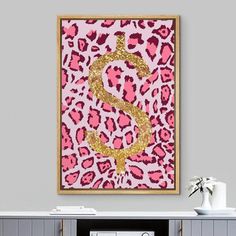 a pink and gold dollar sign is on the wall above a white cabinet in a living room