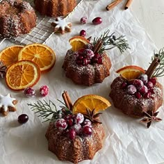 oranges and cinnamon bundt cakes are arranged on a white tablecloth with spices