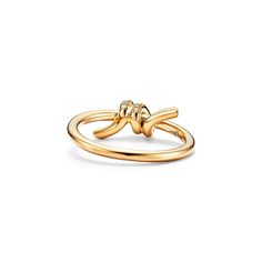 Tiffany Knot is an expression of love’s unwavering bonds. Inspired by an archival bow crafted in 1889, Knot is a symbol of life’s most enduring ties and meaningful connections. This ring is crafted with yellow gold and pavé diamonds, then polished by hand for high shine. Each round brilliant diamond—specifically chosen to meet Tiffany’s high standards—is hand set at precise angles to maximize brilliance. Wear this ring on its own or partnered with classic silhouettes for an unexpected pairing. Tiffany Knot Ring, Tiffany Knot, Symbol Of Life, Love S, Meaningful Connections, Life Symbol, Knot Ring, High Standards, Brilliant Diamond