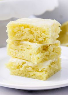 three pieces of cake sitting on top of a white plate next to a lemon wedge