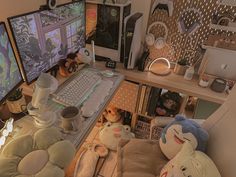 a computer desk with two monitors and stuffed animals