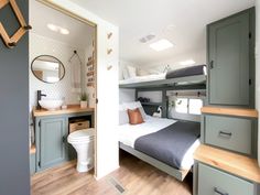 a bedroom with bunk beds and drawers in the corner, next to a bathroom sink