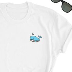 We have express delivery for our shirts! 📦⚡.  From cart to door in just 2-3 days, only for 3.5 USD extra.  You can find the express delivery option in the cart. Whale Shirt, Whale Ocean Tee Shirt, Whale Lover Tee Top, Whale Icon T-Shirt, Whale Gift Shirt, Ocean Lover Friend UNISEX Tee Shirt Gift Friends will love it! This t-shirt feels soft and lightweight, with the right amount of stretch. It's comfortable and flattering for both men and women.  * 100% cotton (heather colors contain polyester) * Fabric weight: 5 oz  * Shoulder-to-shoulder taping * Side-seamed Time for Delivery: * Processing & production time is 1-6 business days (usually 2-3 days). * U.S. Shipping time: 3-5 business days.  * International shipping time: 4-15 days. - Please note European customers: Some orders going to Eu Unisex White T-shirt With Funny Print, White Cotton T-shirt As Gift, White Short Sleeve T-shirt With Funny Print, White Tops With Funny Print For Gift, White Letter Print Top As Gift, White Letter Print Top As A Gift, White Short Sleeve Top As Gift, White Short Sleeve Top For Gift, White Letter Print T-shirt As Gift