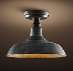 an industrial style light fixture in a dark room with a brown wall and ceiling lighting