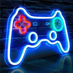 a neon video game controller sign on a brick wall