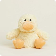 a white stuffed duck sitting in front of a white background with one eye open and the other half closed