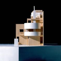 an architectural model of a building made out of wood and white paint on the outside