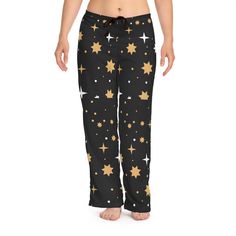 Enjoy a cozy night's sleep with these stylish star print pajama pants. Featuring a black background with gold and white stars, these lounge pants provide a comfortable fit for restful nights. Perfect for both relaxing at home and a good night's sleep, these pajama pants are sure to become your favorite nightwear. 100% polyester White seam thread Light fabric (6 oz/yd² (203 g/m Relaxed comfort fit Back elastic and black drawstring tie Sewn-in care label Assembled in the USA from globally sourced Black And Gold Lounge, Gold Lounge, Pj Bottoms, Fit Back, White Stars, Sleep Shorts, Pajama Robe, Print Pajamas, Care Label