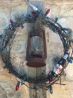 an old fashioned light fixture is decorated with christmas lights and vines on a wooden post