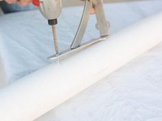 a person using a drill to fix a mattress