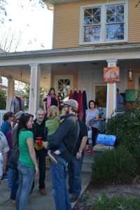 a group of people standing in front of a house with clothes hanging on the porch