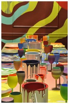 many colorful cups are sitting on the table