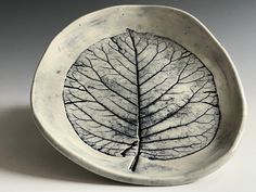 a white bowl with a leaf design on it