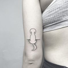 a woman's arm with a small dog tattoo on the left side of her body