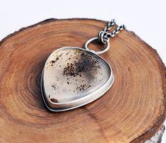 A beautiful and unusual pear shaped Montana Agate is set into recycled fine silver, with a sterling silver back plate, and hangs from a sterling silver chain. The pendant measures approximately 28mm at it's widest by approximately 44mm in total drop (measured from the top of the hoop to the bottom of the setting) A gorgeous, translucent stone with brown speckles. Looks slightly cosmic! The chain is extendible from about 16.5 inches to about 19 inches in length. The silver of the necklace has bee Handmade Silver Pear-shaped Necklace, Handmade Pear-shaped Silver Necklace, Sterling Silver Teardrop Necklace With Natural Inclusions, One Of A Kind Silver Teardrop Necklace, Handmade Pendant Necklace, Montana Agate, Bronze Ring, Nature Inspired Jewelry, Back Plate