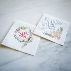 two napkins with monogrammed designs are sitting on a marble countertop next to each other