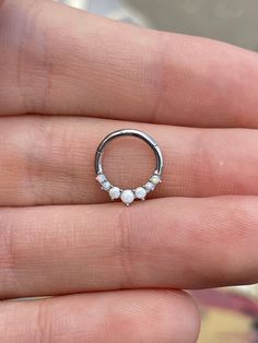 a person is holding a ring with three stones on the inside and outside of it