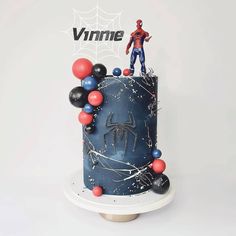 a spiderman cake is decorated with red, white and blue balloons