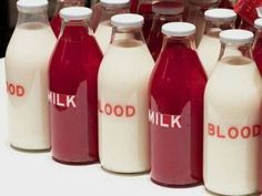 several bottles of milk are lined up on a table