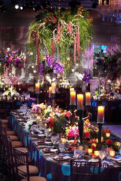 a long table is set with candles and flowers for an elegant dinner or banquet event