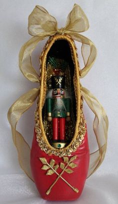 a nutcracker in a red shoe with gold trim