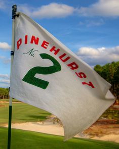 a white flag with the number 2 on it in front of a green golf course