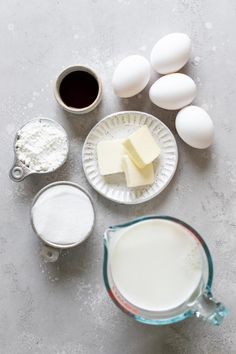 eggs, butter and other ingredients on a gray surface with a glass measuring cup next to them