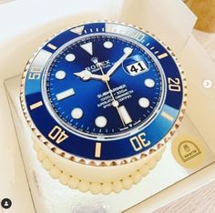 a blue and gold rolex watch sitting in a box