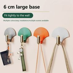 four different colored fan shaped key chains hanging on the side of a wall with text that reads, 6 cm large base